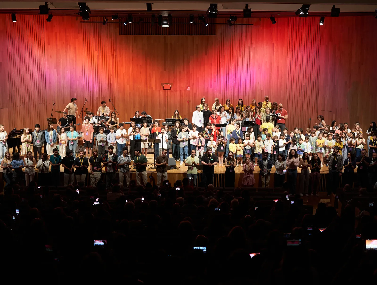 Palco cheio de alunos e professores num recital d'Os Músicos