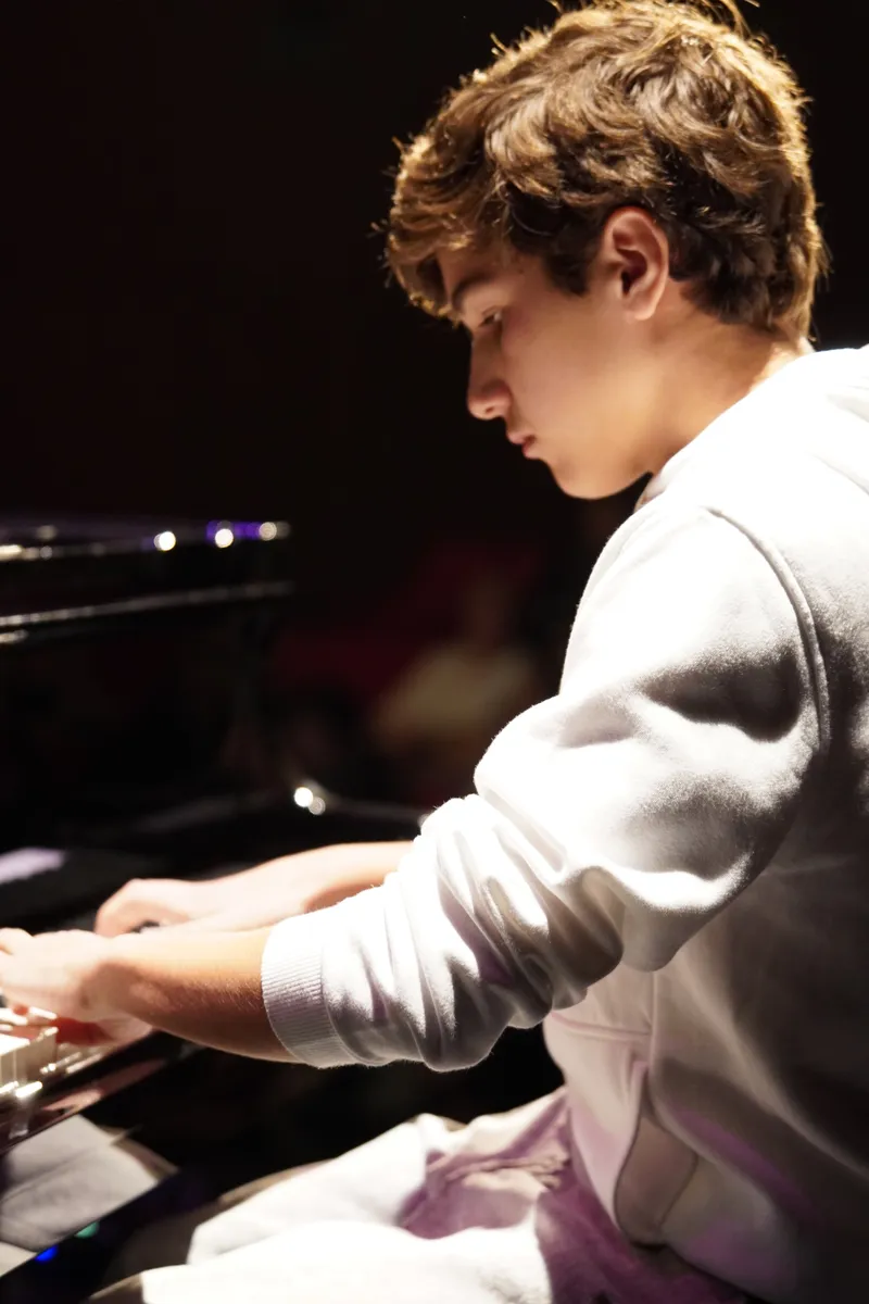 Aluno ao piano de cauda no Recital de Primavera